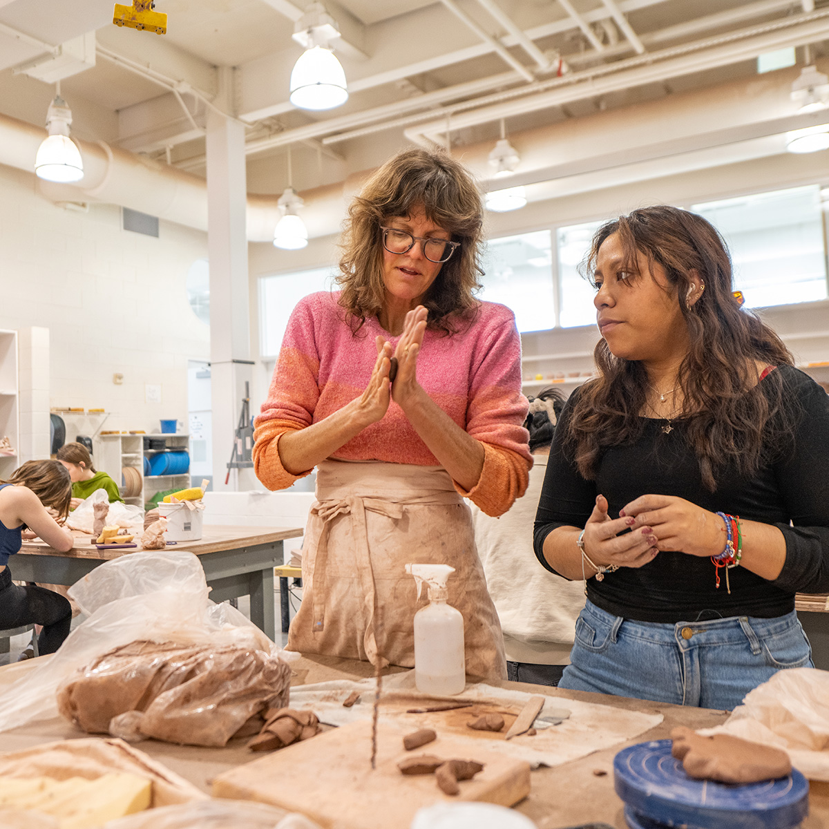 Professor Meredith Brickell with students in Peeler's pottery room